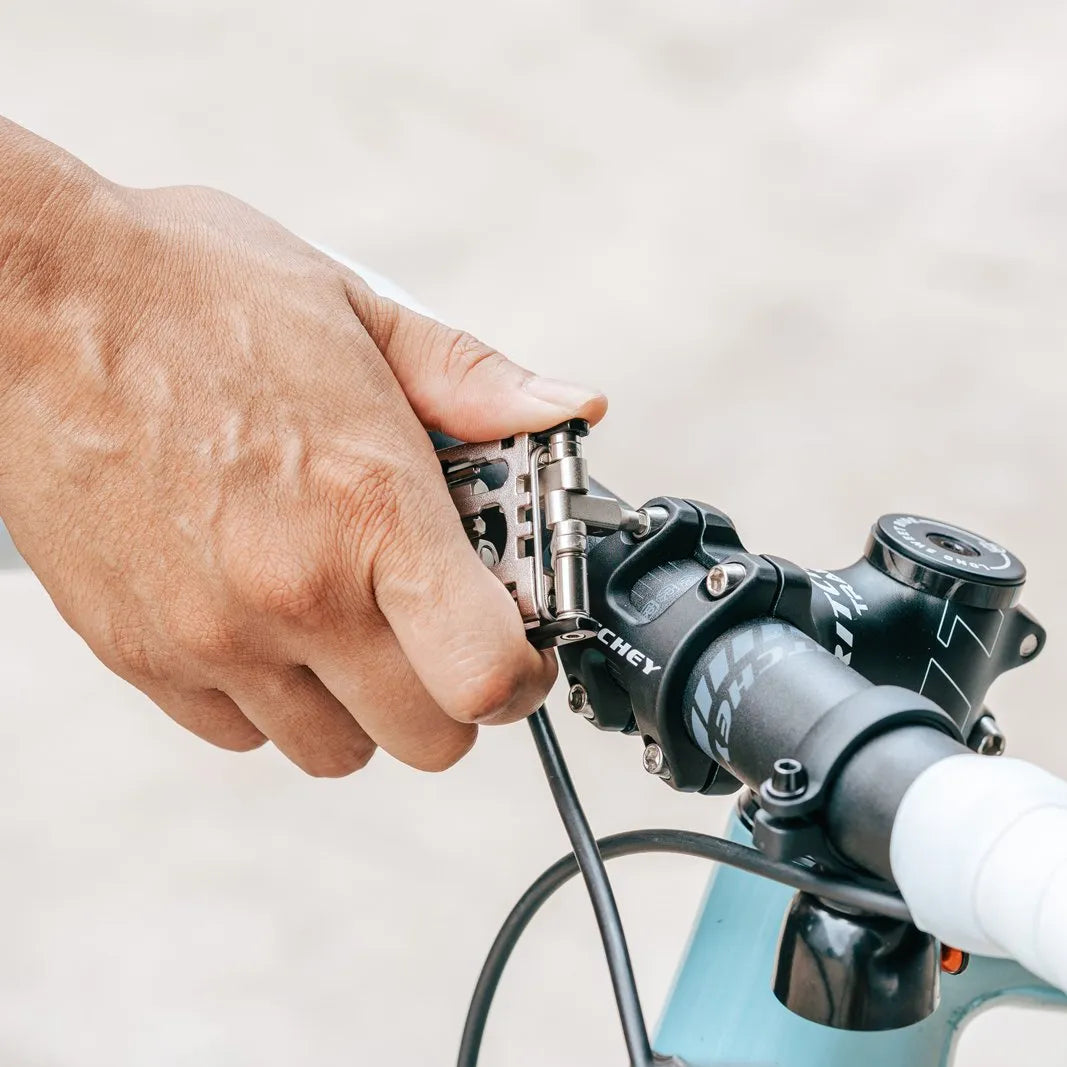 Granite Diverse 20 multi tool gripping a bicycle handlebar with a blurred background